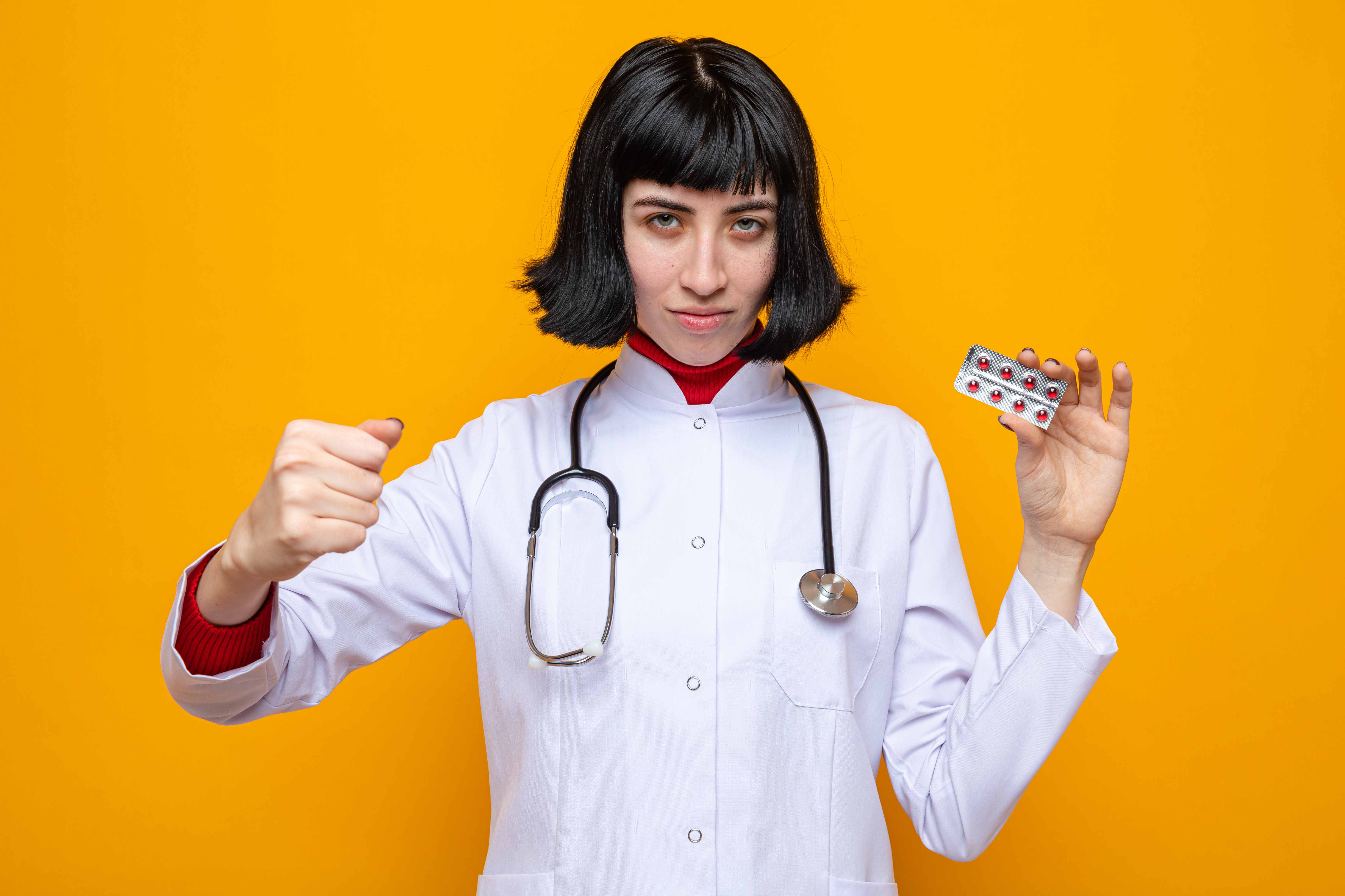 Healthcare professional confidently holding a blister pack of supplement tablets